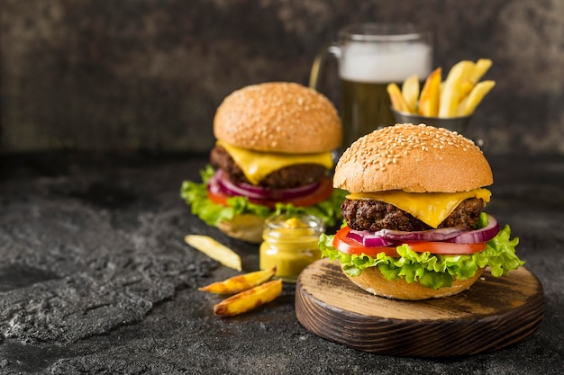 Hamburguesas de alto ángulo con papas fritas, salsa y cerveza con espacio de copia