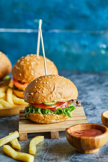 Hamburguesas con patatas fritas en la plancha de madera