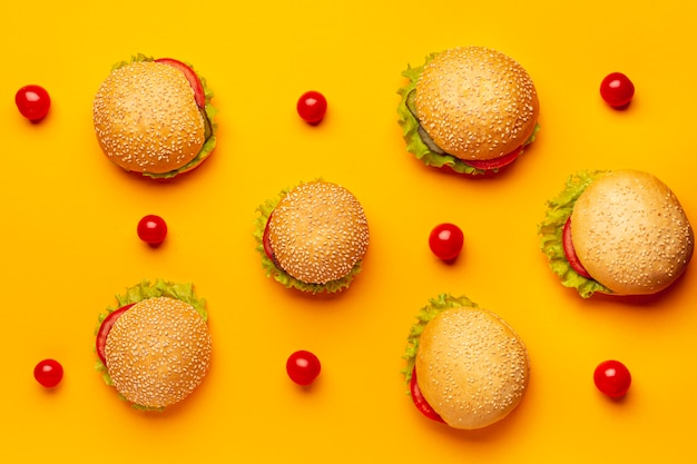 Hamburguesas planas con fondo naranja.