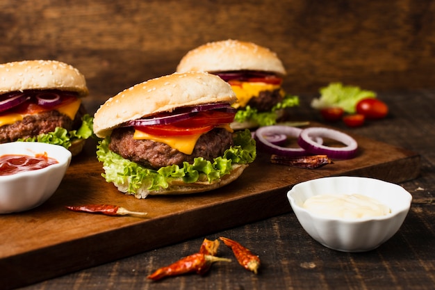 Hamburguesas con salsa de tomate en bandeja de madera