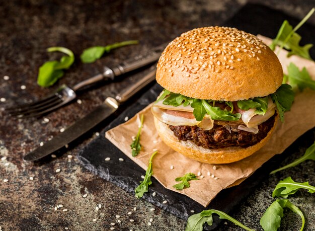 Hamburguesas de ternera vista frontal con tocino y cubiertos