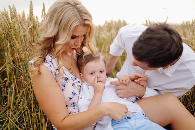 Happy Young Family Dad, mamá e hijo pequeño se ve feliz en el parque