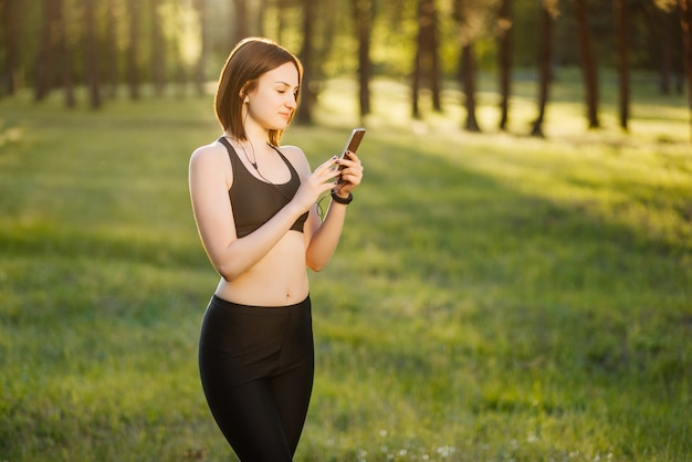 Happy young sportsgirl hace selfie retrato en smartphone.