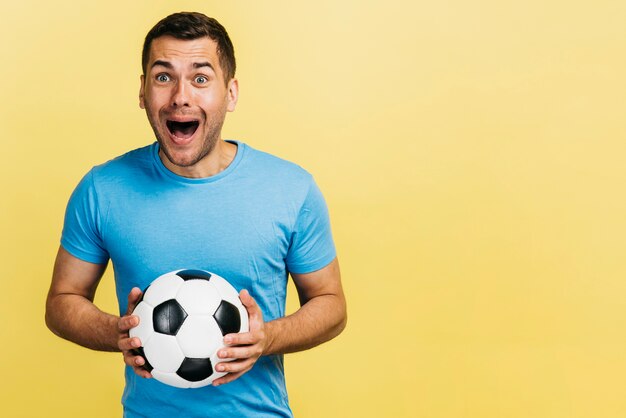 Happyman sosteniendo una pelota de fútbol