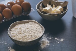 Foto gratuita harina de mantequilla y huevos en el primer plano de la mesa de la cocina
