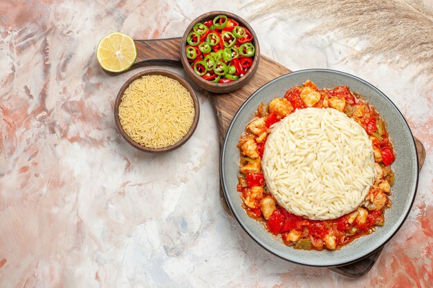 Harina de pollo con tomate con ensalada de arroz blanco, pimiento y limón cortado