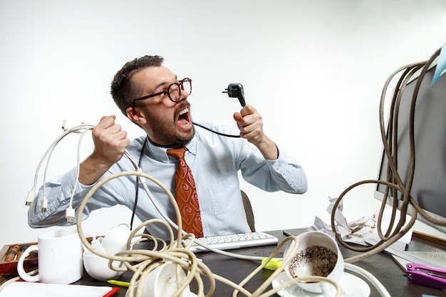 Foto gratuita hay muchos cables en el lugar de trabajo y el hombre se enreda constantemente en ellos.