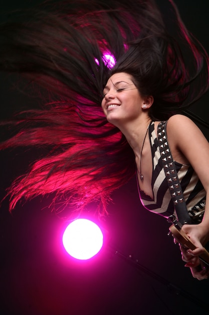 Foto gratuita heavy metal mujer tocando la guitarra eléctrica