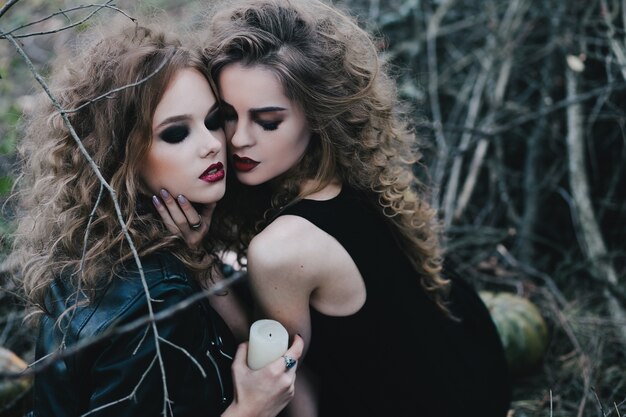 Hechiceras sujetando con una vela blanca