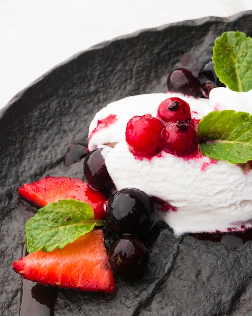 Helado de ángulo alto en pizarra con frutas