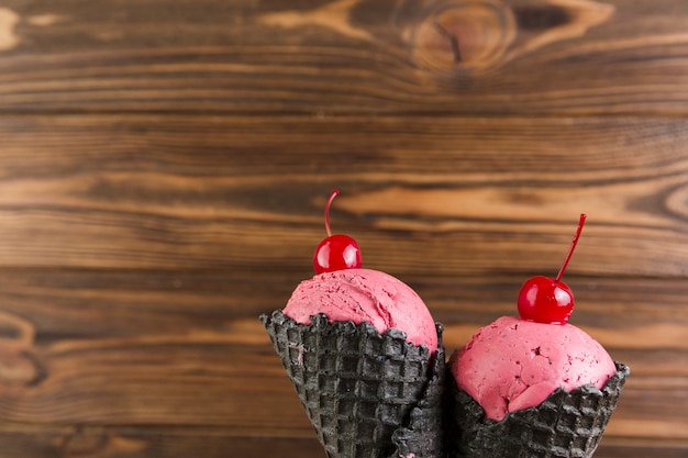 Foto gratuita helado de cereza en conos de gofres negros