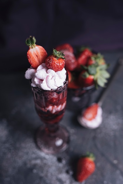 Helado de chocolate con crema batida y fresa en copa.