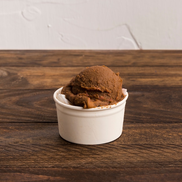 Helado de chocolate en un tazón blanco sobre superficie de madera