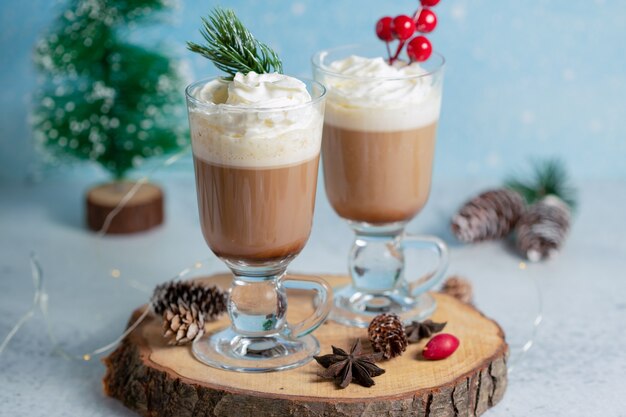 Helado de dos tazones sobre tabla de madera con adornos navideños.