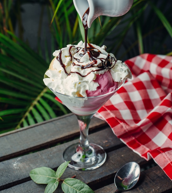 helado de frambuesa y manzana cubierto con crema batida y salsa de chocolate