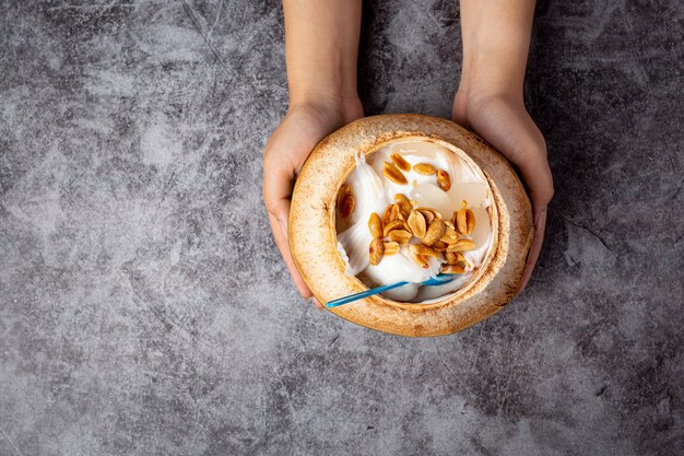 Helado de leche de coco en la cáscara de coco sobre la superficie oscura