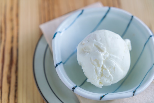 helado de leche en un tazón en la mesa de madera.