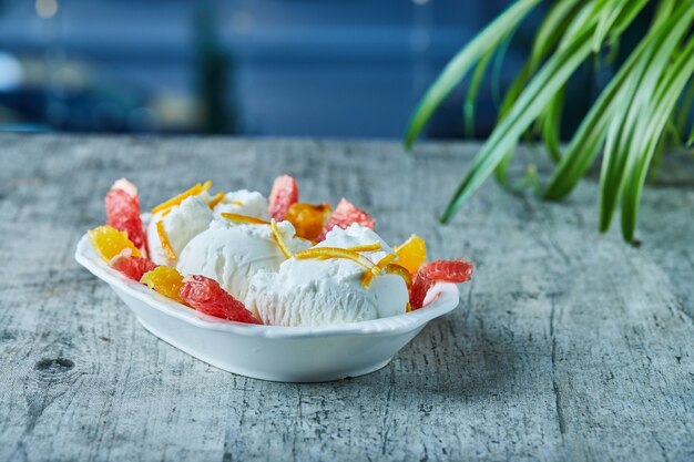 Helado con rodajas de pomelo y naranja en un tazón blanco