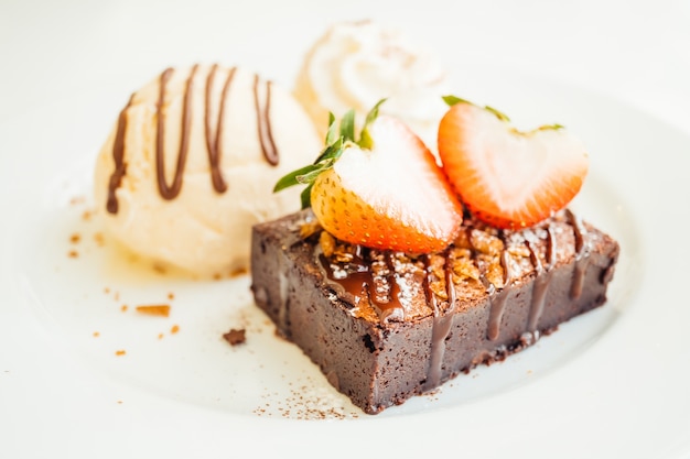 Helado de vainilla con pastel de brownie de chocolate con fresa en