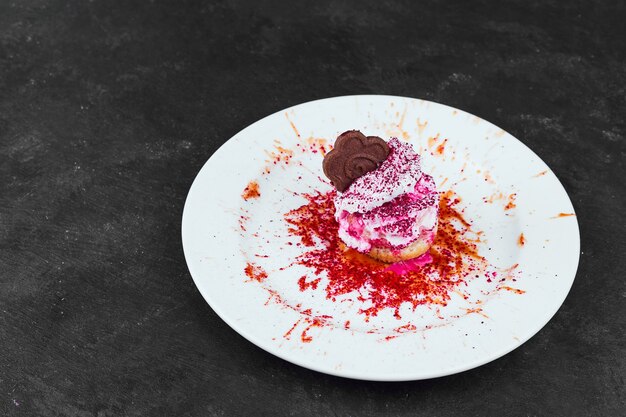 Helado de vainilla con sirope de fresa y chocolate en un plato blanco.