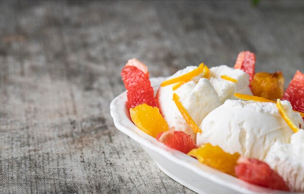 Helado de vainilla con trozos de sandía y frutas de naranja.