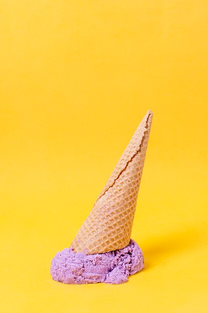 Helado violeta y cono en el piso