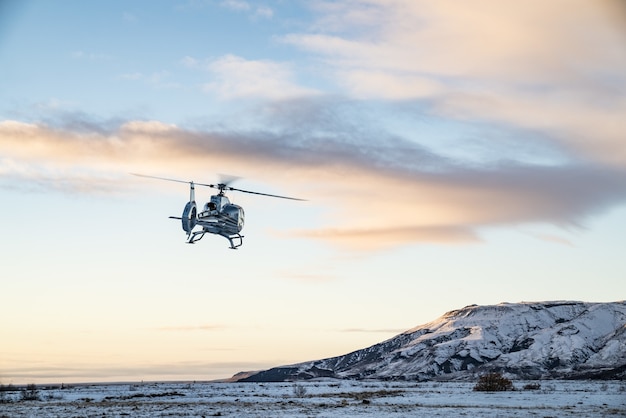 Helicóptero sobrevuela la tundra cubierta de nieve.