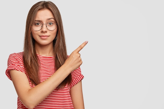 La hembra alegre positiva indica un espacio de copia en blanco para contenido promocional.