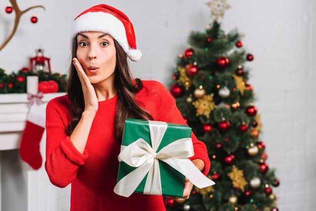 Hembra asombrada con caja de regalo verde.