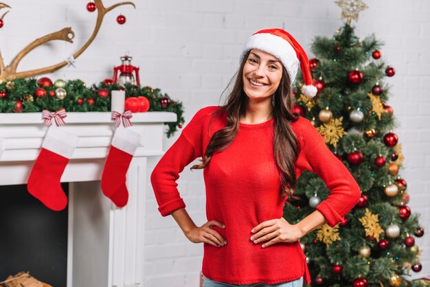 Hembra joven cerca de arbol de navidad