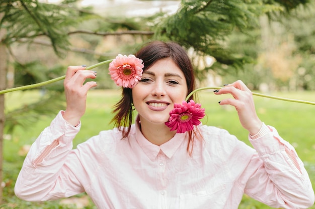 Hembra joven con flores cerca de la cara