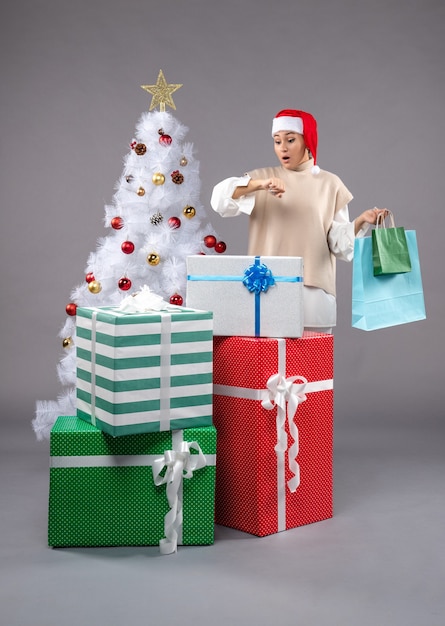 hembra joven con regalos de navidad en la luz