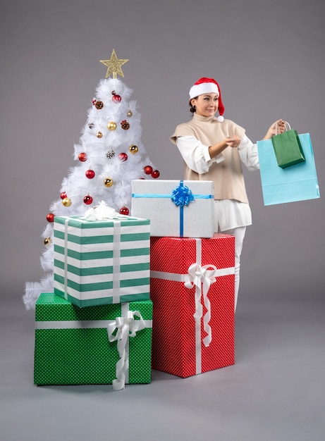 hembra joven con regalos de navidad en la luz