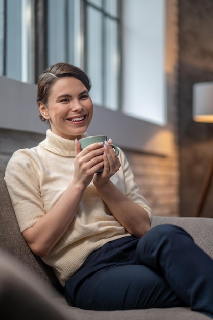 Hembra joven sonriente con una taza de café