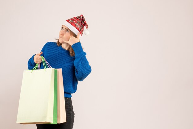 Hembra joven sosteniendo paquetes con regalos en blanco