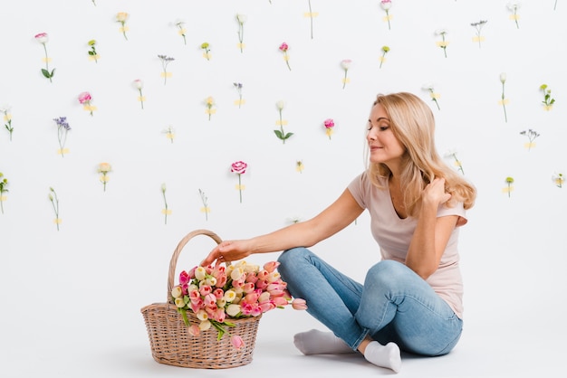 Hembra joven con tulipanes en canasta