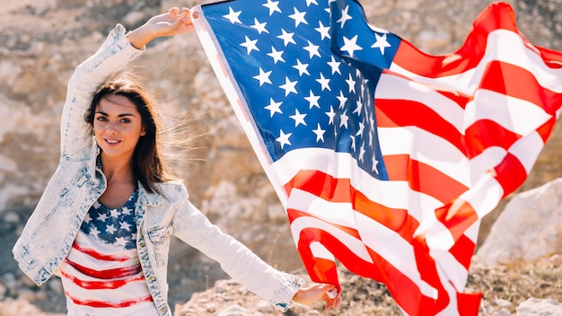 Foto gratuita hembra sonriente con bandera mirando a cámara