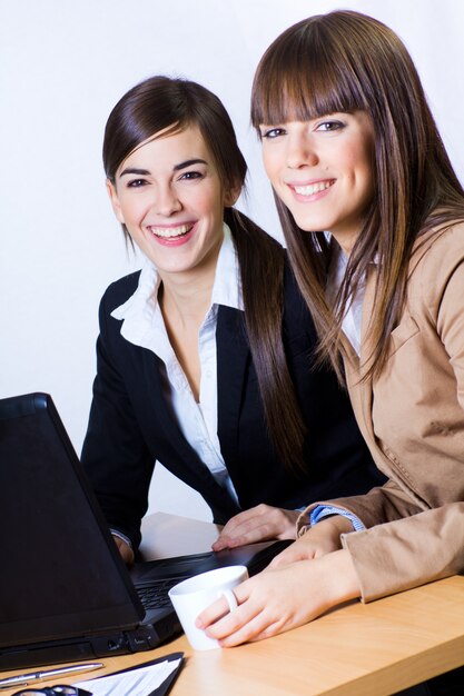 Las hembras sonriendo mientras trabajaba en la computadora portátil