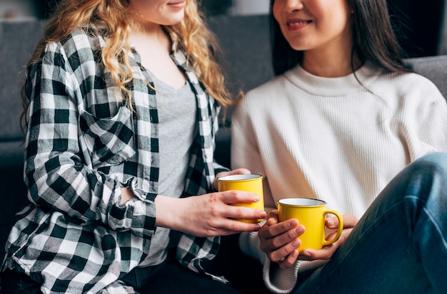 Hembras sonrientes sosteniendo tazas de café