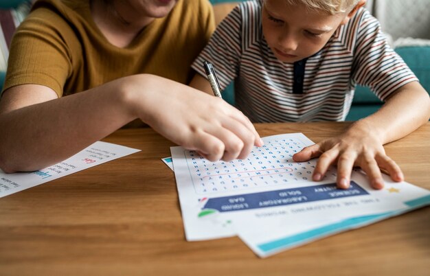 Hermana jugando búsqueda de palabras con su hermano pequeño