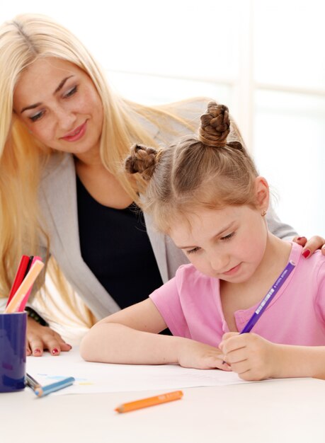 La hermana mayor está enseñando a la hermana menor a dibujar