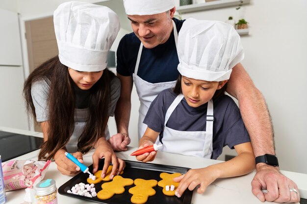 Hermanas cocinando en la cocina con su padre.