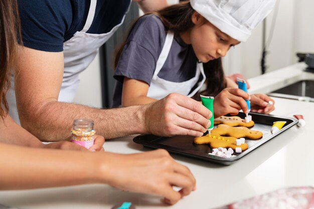 Hermanas cocinando en la cocina con su padre.