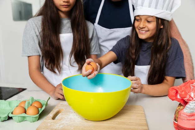 Hermanas cocinando en la cocina con su padre.