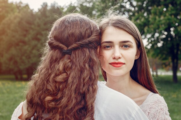 Hermanas elegantes y con estilo en un parque de primavera