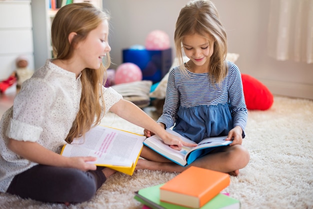 Hermanas encantadoras hojeando sus libros de aventuras