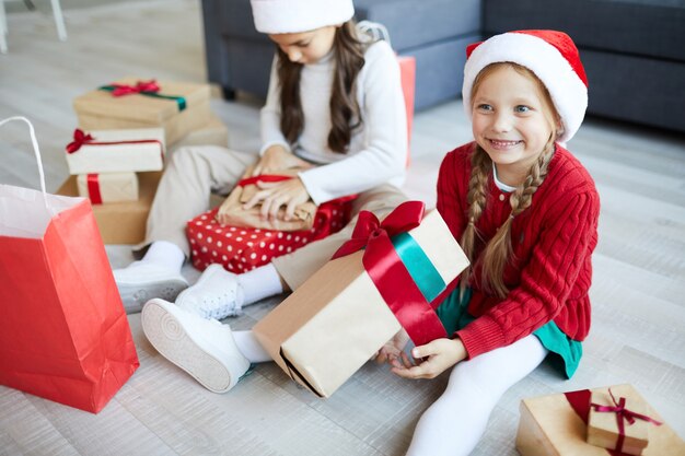 Hermanas felices desenvolver regalos o regalos de Navidad