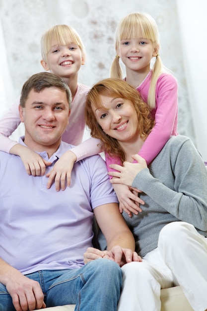 Hermanas gemelas abrazando a sus padres