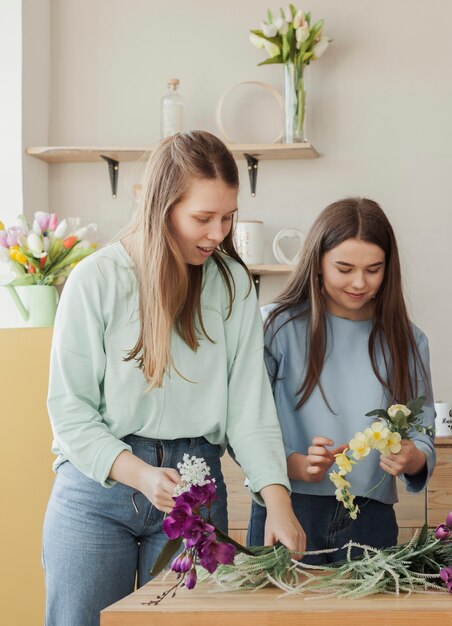Hermanas hermosas jovenes que sostienen las flores