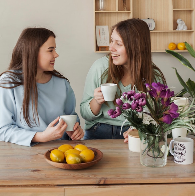 Hermanas hermosas jóvenes tomando café